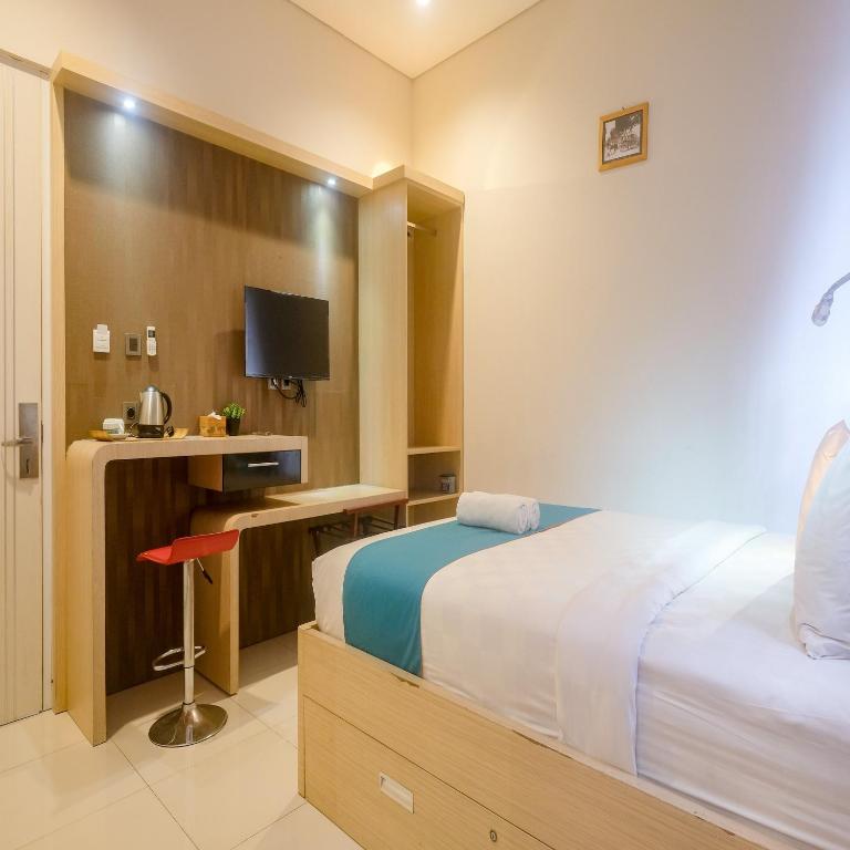 Postel nebo postele na pokoji v ubytování Sans Hotel Grand Omah Sastro Yogyakarta