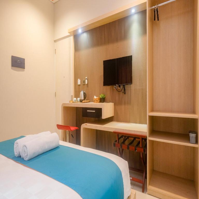 Postel nebo postele na pokoji v ubytování Sans Hotel Grand Omah Sastro Yogyakarta