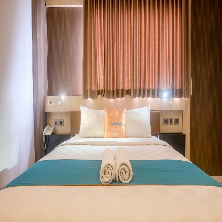 Postel nebo postele na pokoji v ubytování Sans Hotel Grand Omah Sastro Yogyakarta