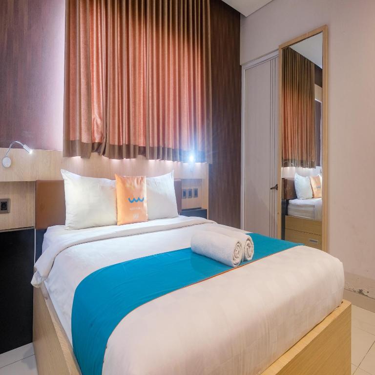 Postel nebo postele na pokoji v ubytování Sans Hotel Grand Omah Sastro Yogyakarta