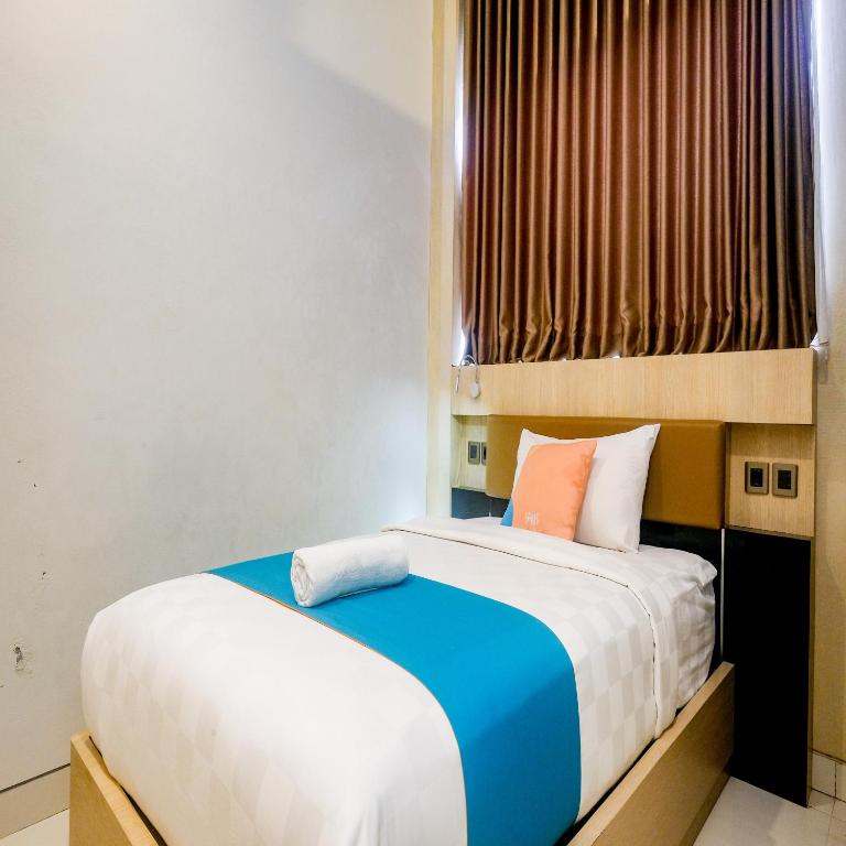 Postel nebo postele na pokoji v ubytování Sans Hotel Grand Omah Sastro Yogyakarta