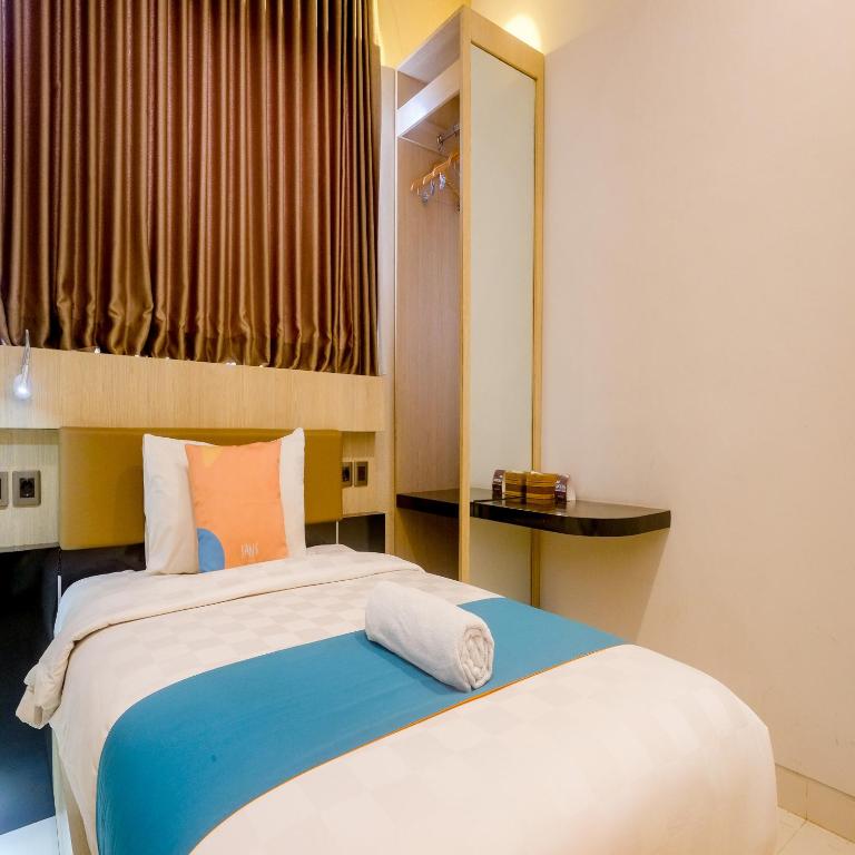 Postel nebo postele na pokoji v ubytování Sans Hotel Grand Omah Sastro Yogyakarta