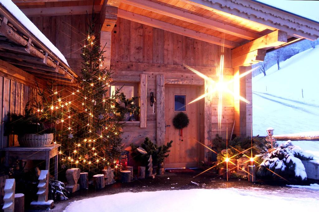 een kerstboom voor een hut met kerstverlichting bij Appartements Wallner in Uttendorf