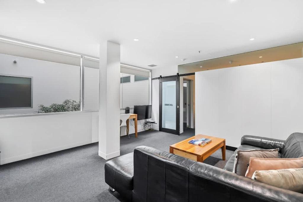 a living room with a couch and a table at Gibson Mill waterfront warehouse apartment - 104 in Hobart