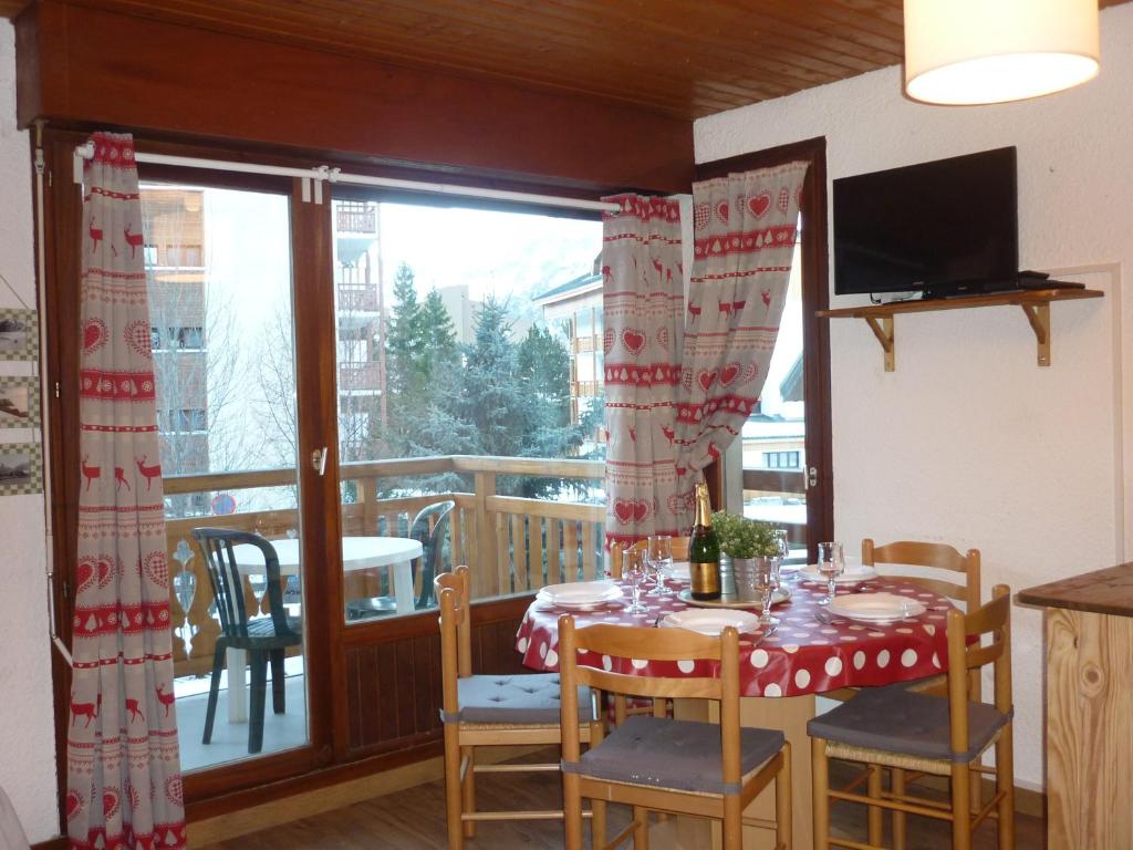 uma sala de jantar com uma mesa e uma varanda em Les Alberges em Les Deux Alpes
