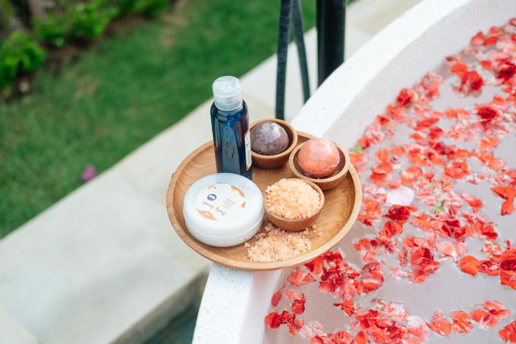 een bord met cosmetica op een tafel met bloemen bij Casa Nebula Villa in Kerobokan