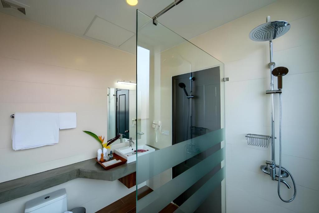 a bathroom with a glass shower and a sink at Vihara The City of Temples in Siem Reap
