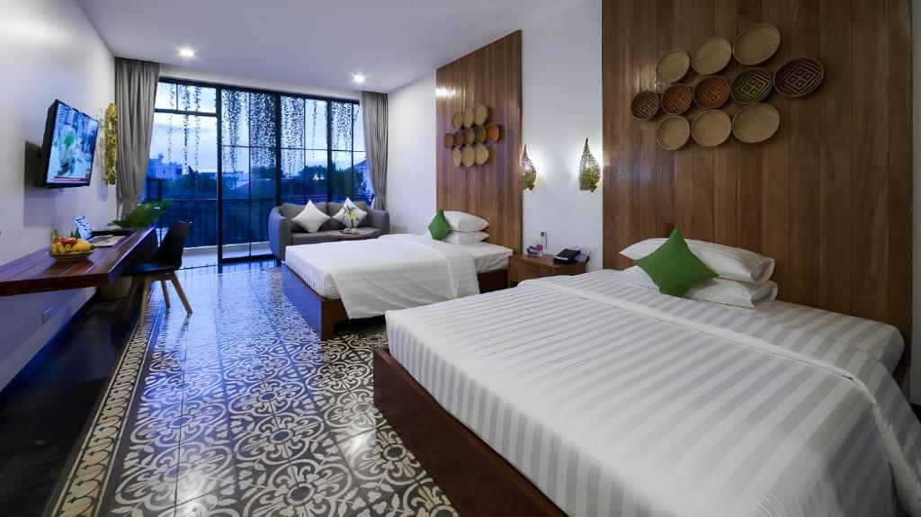 a hotel room with two beds and a couch at Vihara The City of Temples in Siem Reap