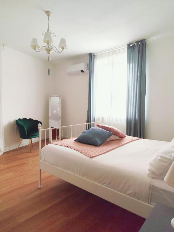a bedroom with a bed with a window and a chair at Maison Bon Ton in Villafranca dʼAsti