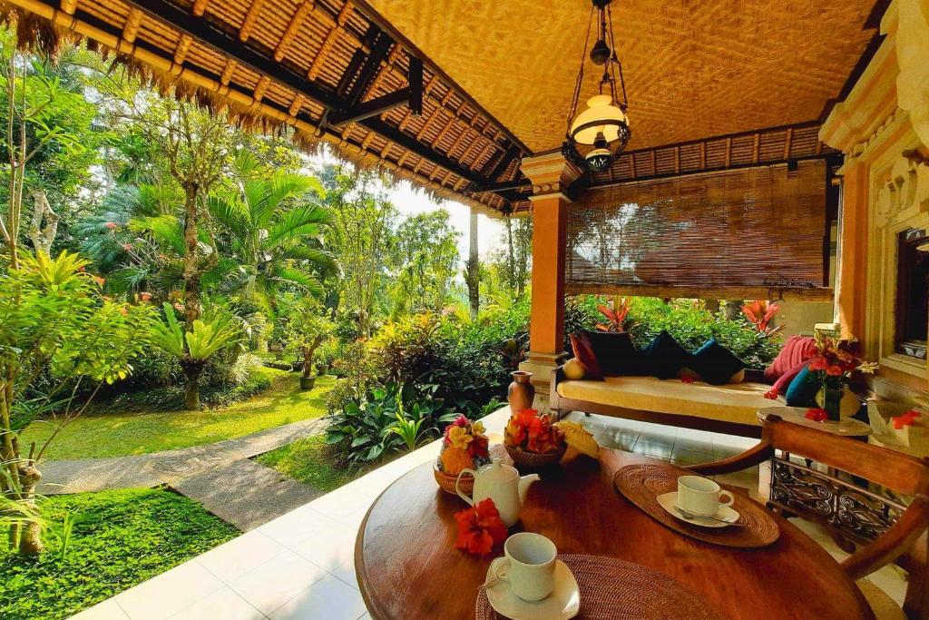 a living room with a table and a couch at Jivaa 1 BR Superior Garden View ZN239 in Ubud