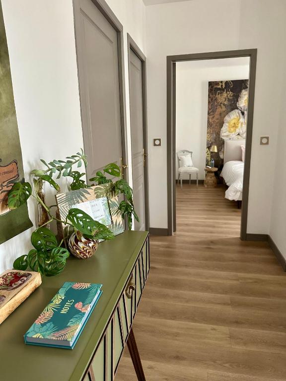 une chambre avec une table, un livre et des plantes dans l'établissement Coural' Chic, à Narbonne