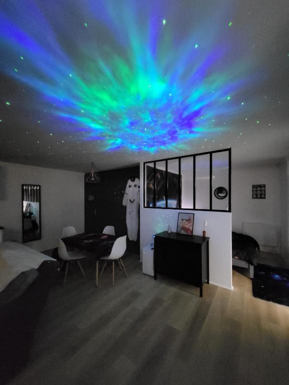 d'un salon avec un plafond lumineux bleu et vert dans l'établissement Studio spatial - Place de la République, au Mans