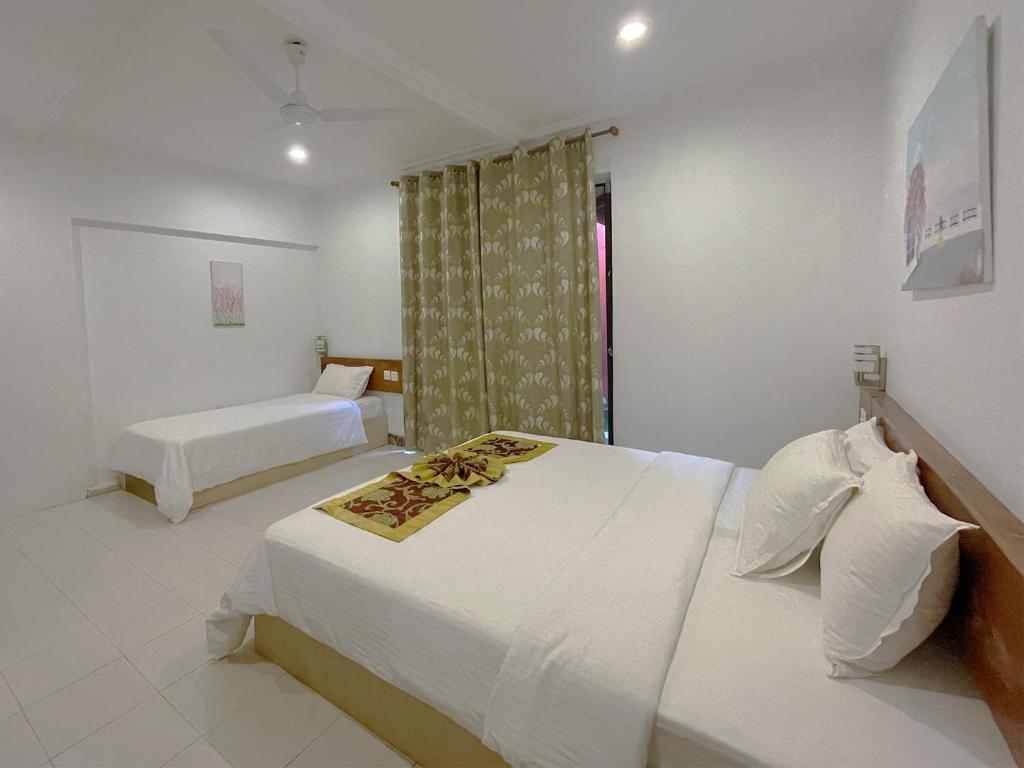 Postel nebo postele na pokoji v ubytování Paradise Retreat, Maafushi