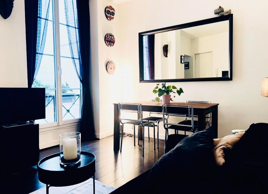 - un salon avec une table et un miroir dans l'établissement Appartement d'Architecte chic et élegant, à Paris