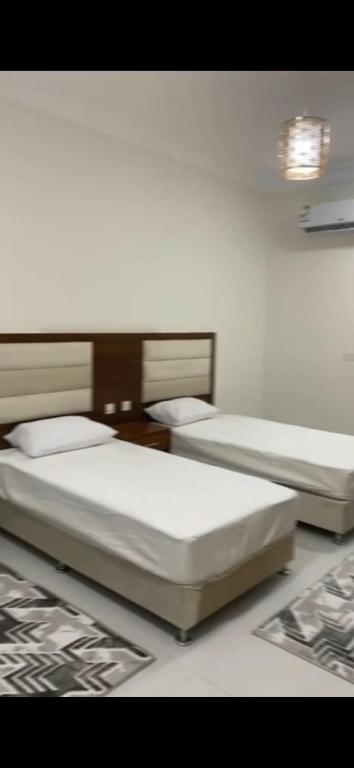 two beds sitting in a room with at Evora إيفورا in Sharurah
