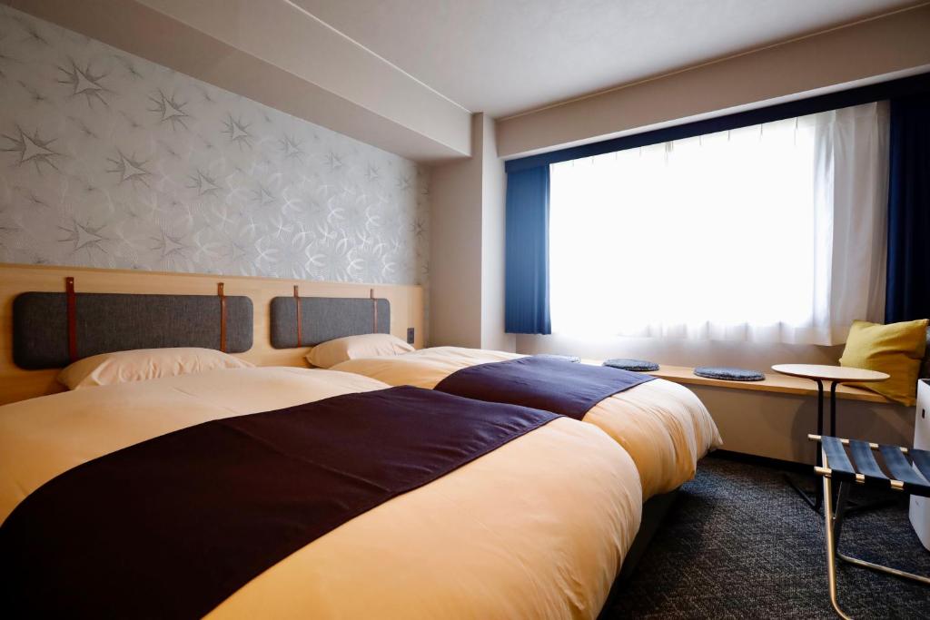 Postel nebo postele na pokoji v ubytování Kyoto Pleasant Hotel