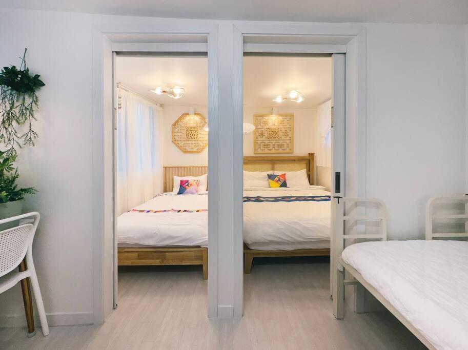 een slaapkamer met twee bedden en een spiegel bij Inwangsan Stay in Seoul