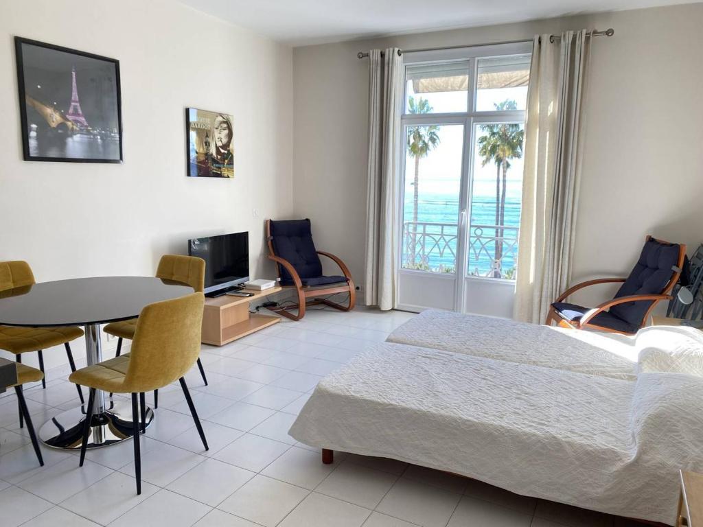une chambre avec un lit, une table et des chaises dans l'établissement 204 - Cannes La Croisette - Studio face mer avec balcon, à Cannes