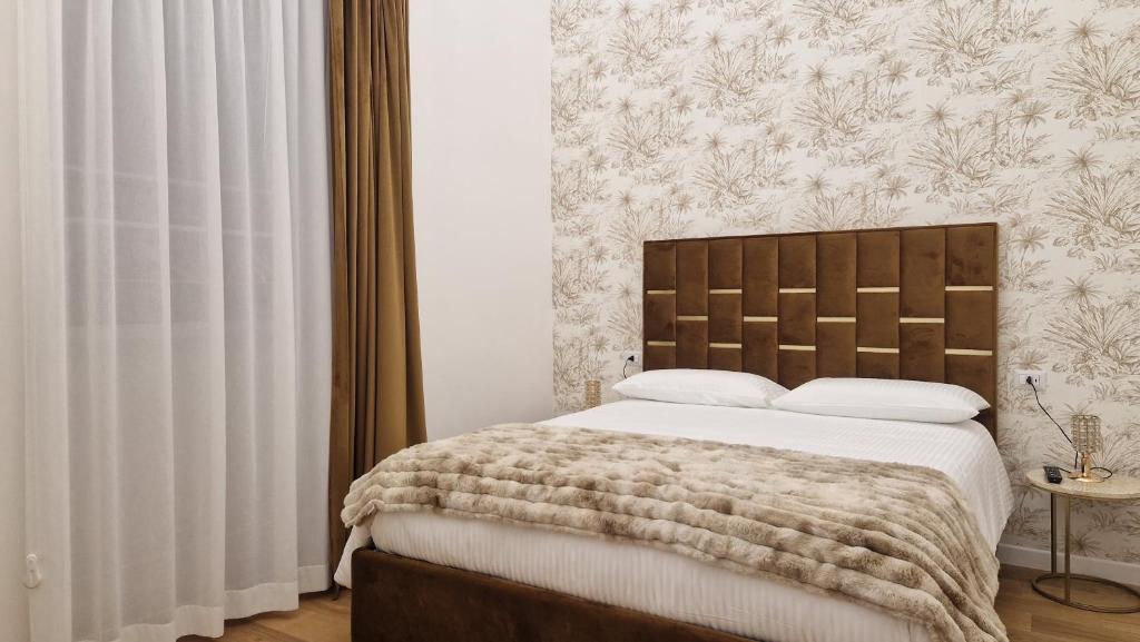 a bedroom with a large bed with a brown headboard at La Maison del Duomo in Catania