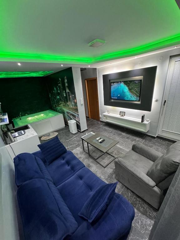 a living room with a blue couch and a flat screen tv at Apartman S&V 2 Istocno Sarajevo Lukavica sa Jacuzzi Lux Spa Hilandarska Centar in Lukavica