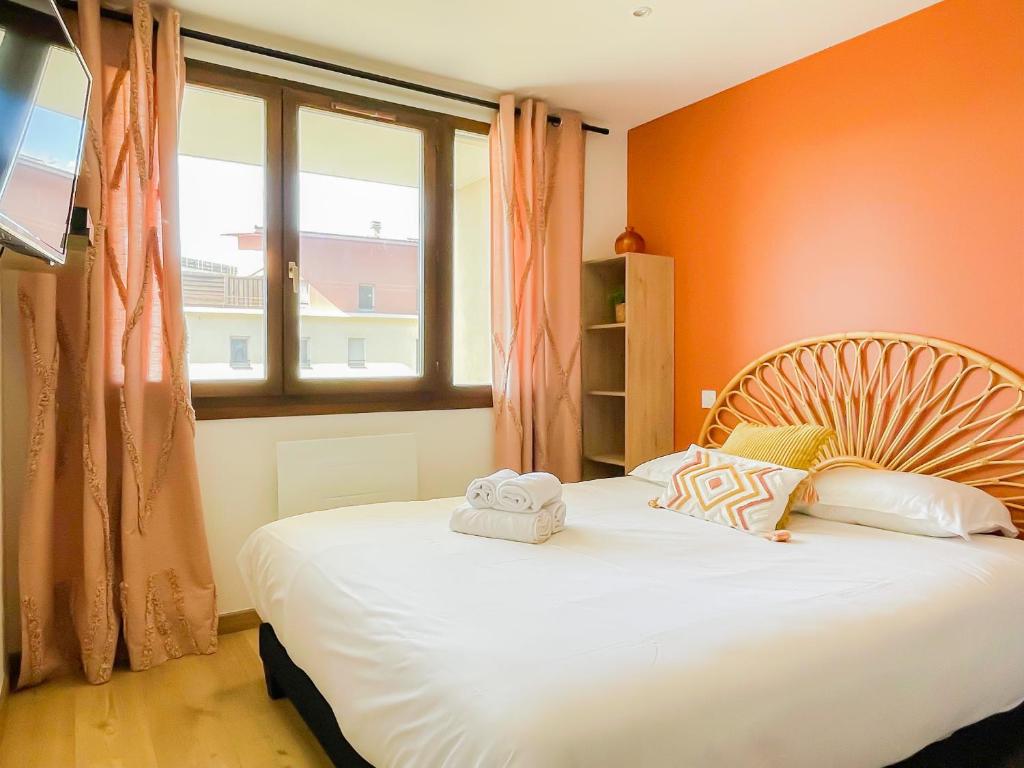 - une chambre avec un lit aux murs orange et une fenêtre dans l'établissement Soleil d or proche de la vielle ville, à Annecy