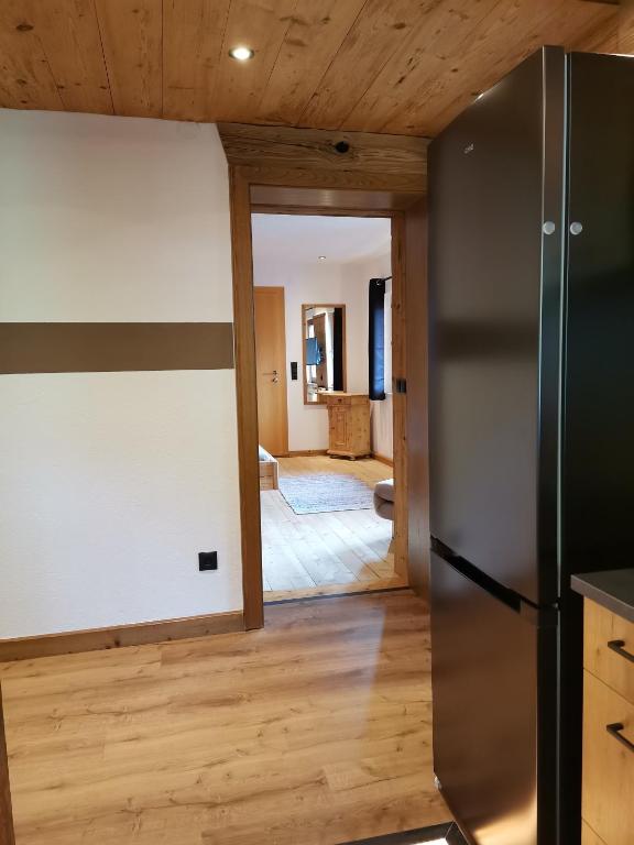 a kitchen with a refrigerator and a living room at Pension Sonderbichlhof in Pankrazberg