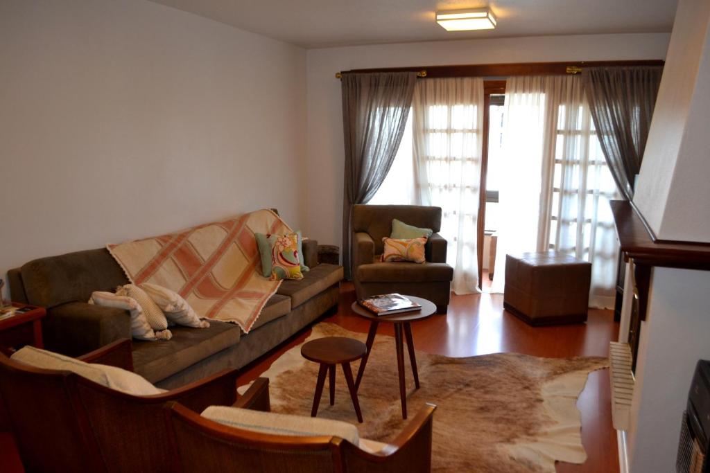 sala de estar con sofá y mesa en Apartamento Central, en Gramado