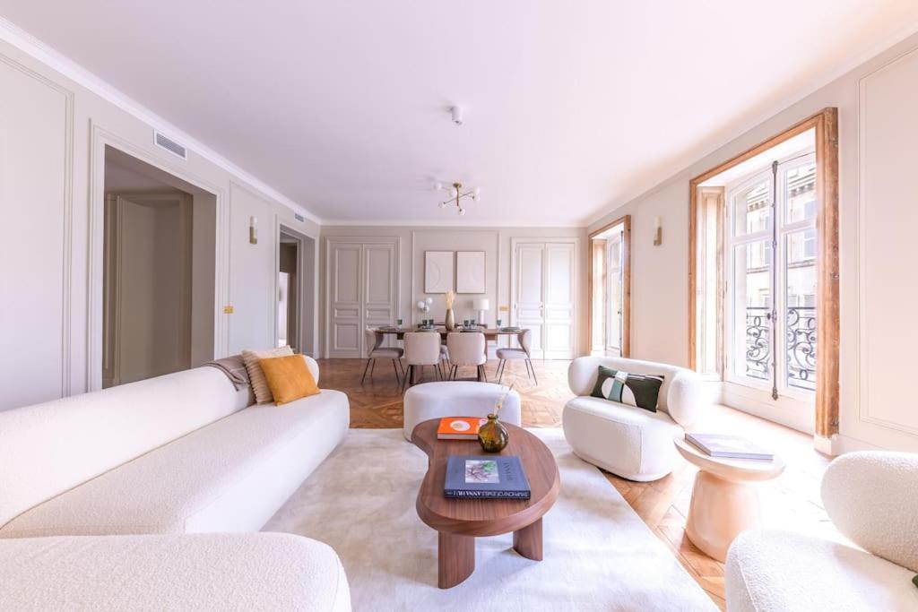 un salon avec un canapé blanc et une table dans l'établissement Arc de Triomphe Luxury 3 Bed 3,5 Bath, à Paris