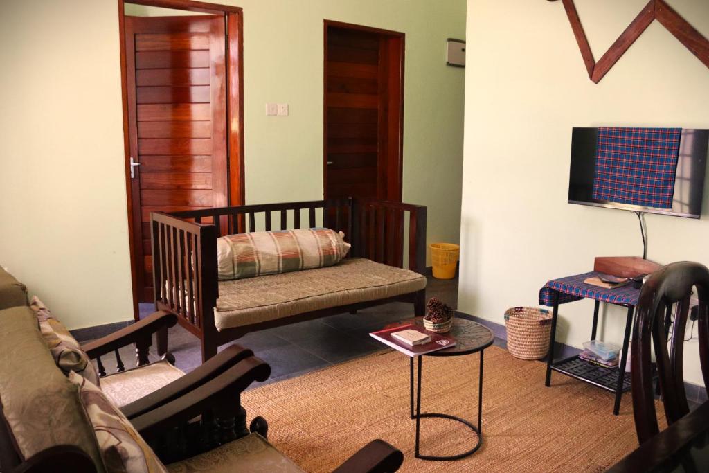 een woonkamer met een wieg en een tv bij My Moka Arusha in Arusha