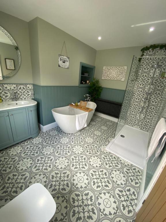a bathroom with a tub and a shower and a sink at Harbour Heights Whitby in Whitby