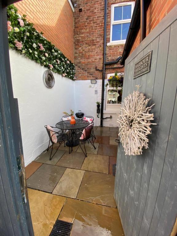 a patio with a table and chairs in a courtyard at Harbour Heights Whitby in Whitby