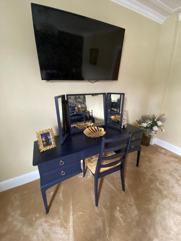 a blue desk with a chair and a mirror at Harbour Heights Whitby in Whitby