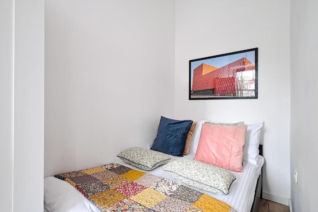 a bedroom with a bed with colorful pillows at CityCenterApartments/M32/2A in Bielsko-Biala