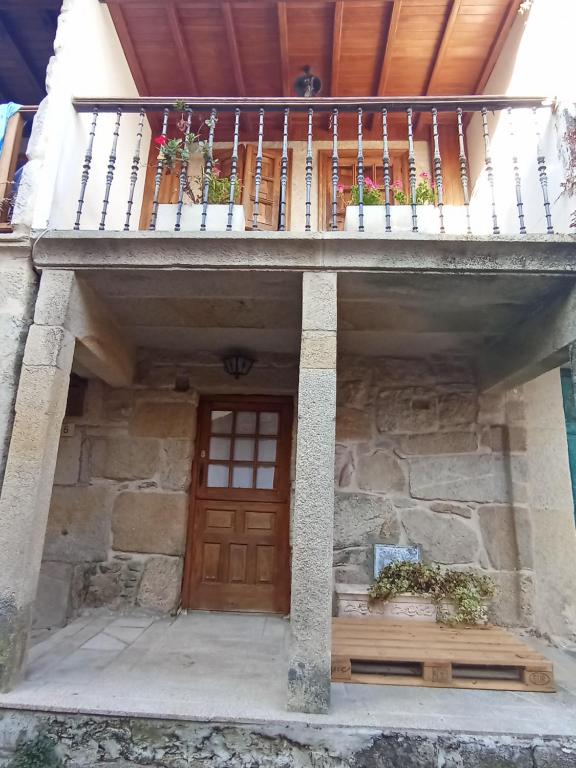 Casa con puerta de madera y balcón en Casa da laxe, en Combarro