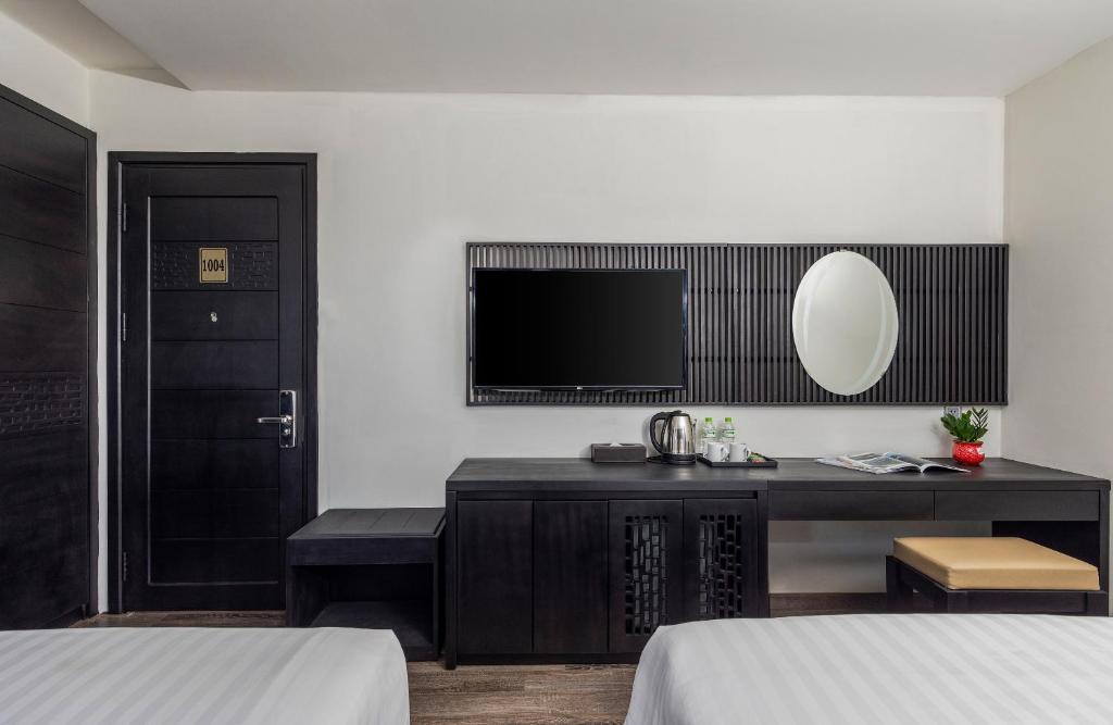 The entry-side work and storage area of a twin room, with a TV, kettle station and small stool.
