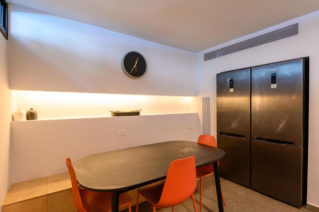 a kitchen with a table and chairs and a refrigerator at Rokah Luxury Villa at Ramat HaHayal in Tel Aviv