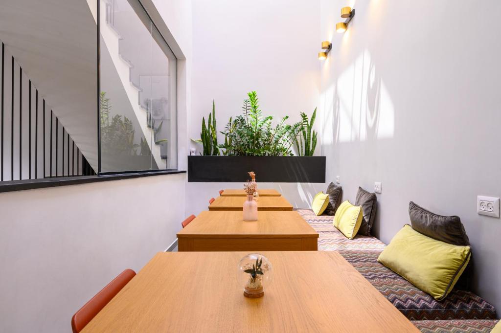 a room with wooden tables and yellow pillows at Rokah Luxury Villa at Ramat HaHayal in Tel Aviv