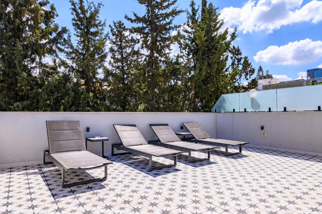a row of chairs and tables on a roof at Rokah Luxury Villa at Ramat HaHayal in Tel Aviv
