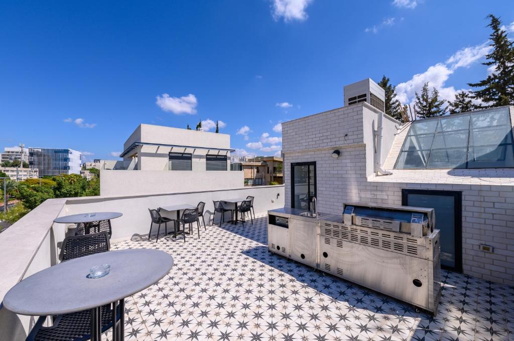 a patio with tables and chairs on a building at Rokah Luxury Villa at Ramat HaHayal in Tel Aviv