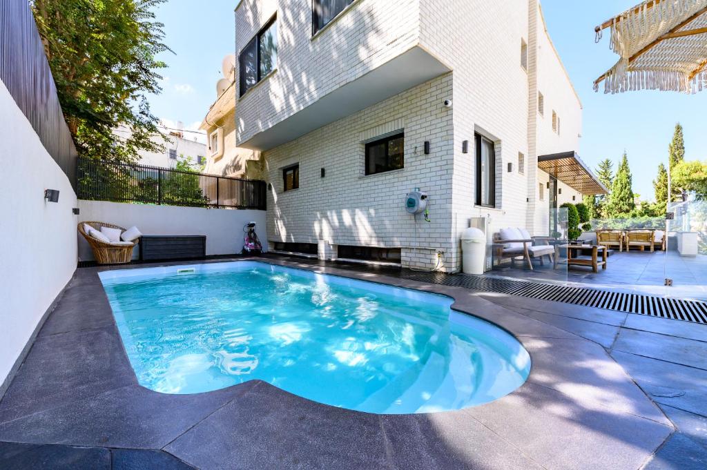 a swimming pool in the backyard of a house at Rokah Luxury Villa at Ramat HaHayal in Tel Aviv