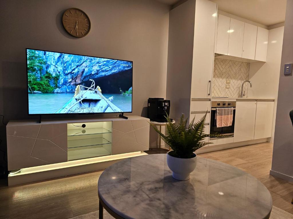 a living room with a large tv and a table at Urban Retreat - Central Auckland Stay in Auckland