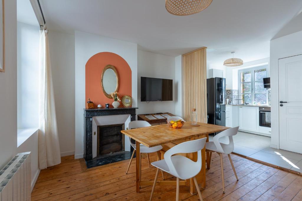 un salon avec une table et des chaises et une cheminée dans l'établissement La Sirène - Entre châteaux et Beauval, à Romorantin-Lanthenay