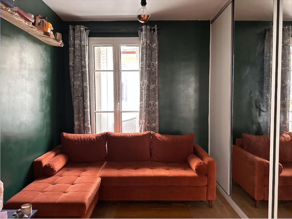 - un salon avec un canapé brun en face d'une fenêtre dans l'établissement Art House bastille 2 bed apartment w balcony, 11eme super trendy neighbourhood, à Paris