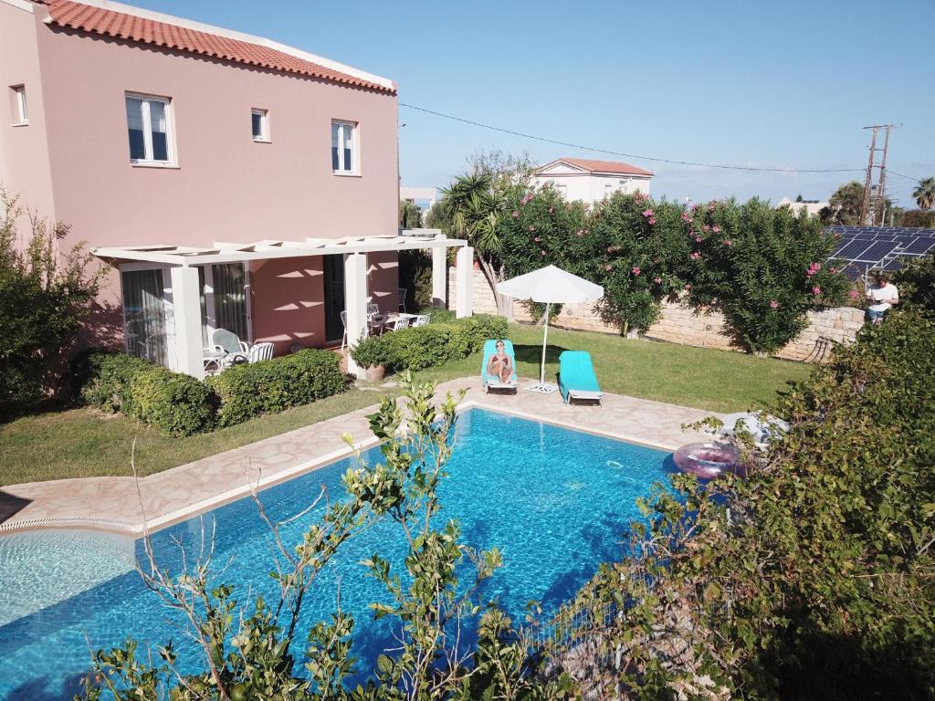 a house with a swimming pool in front of a house at Elya in Prínos