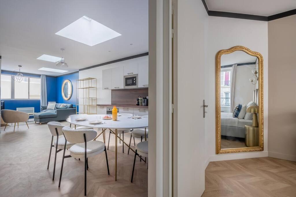 une salle à manger avec une table et un miroir dans l'établissement Maison proche Atelier des Lumieres Rue Oberkampf, à Paris