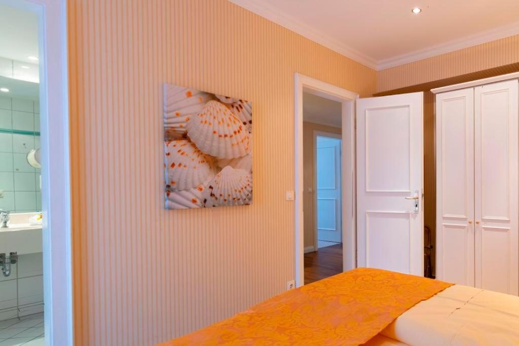 a bedroom with a bed and a painting on the wall at Strandhotel Sylt Westerland in Westerland