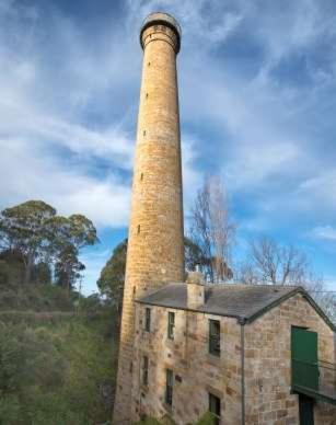 a tall brick tower sitting on top of a building at Treetops-Large Home 9km to CBD Sleeps 10 in Hobart
