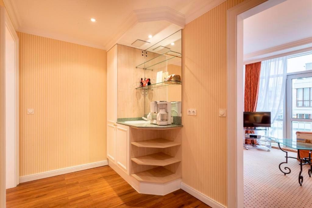 a room with a kitchen with yellow walls at Strandhotel Sylt Westerland in Westerland