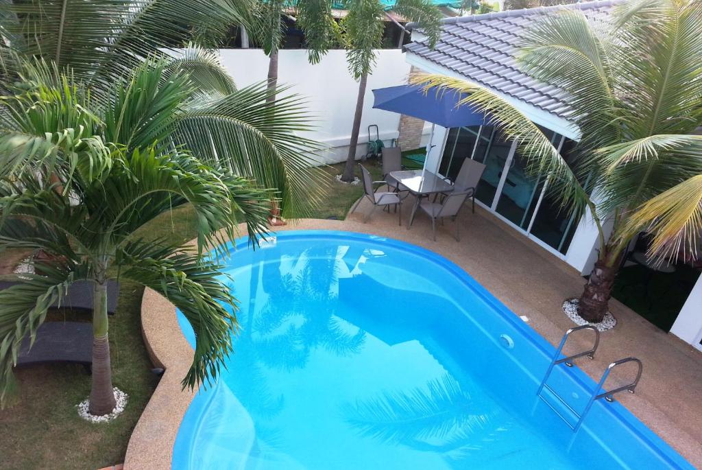 een uitzicht over een zwembad met palmbomen bij Coconut Palms in Kantharawichai