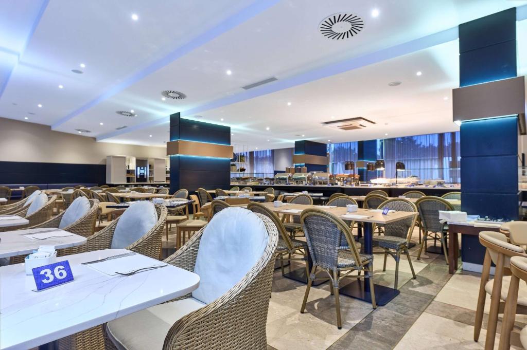 a restaurant with white tables and chairs at TRYP by Wyndham Lisboa Caparica Mar in Costa da Caparica